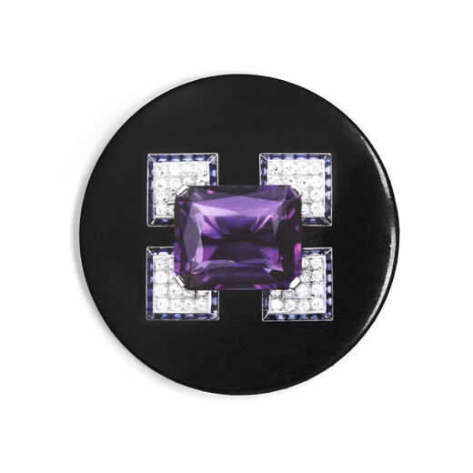 A simple circular pocket mirror, black with Cartier's Angular diamond and amethyst brooch featured